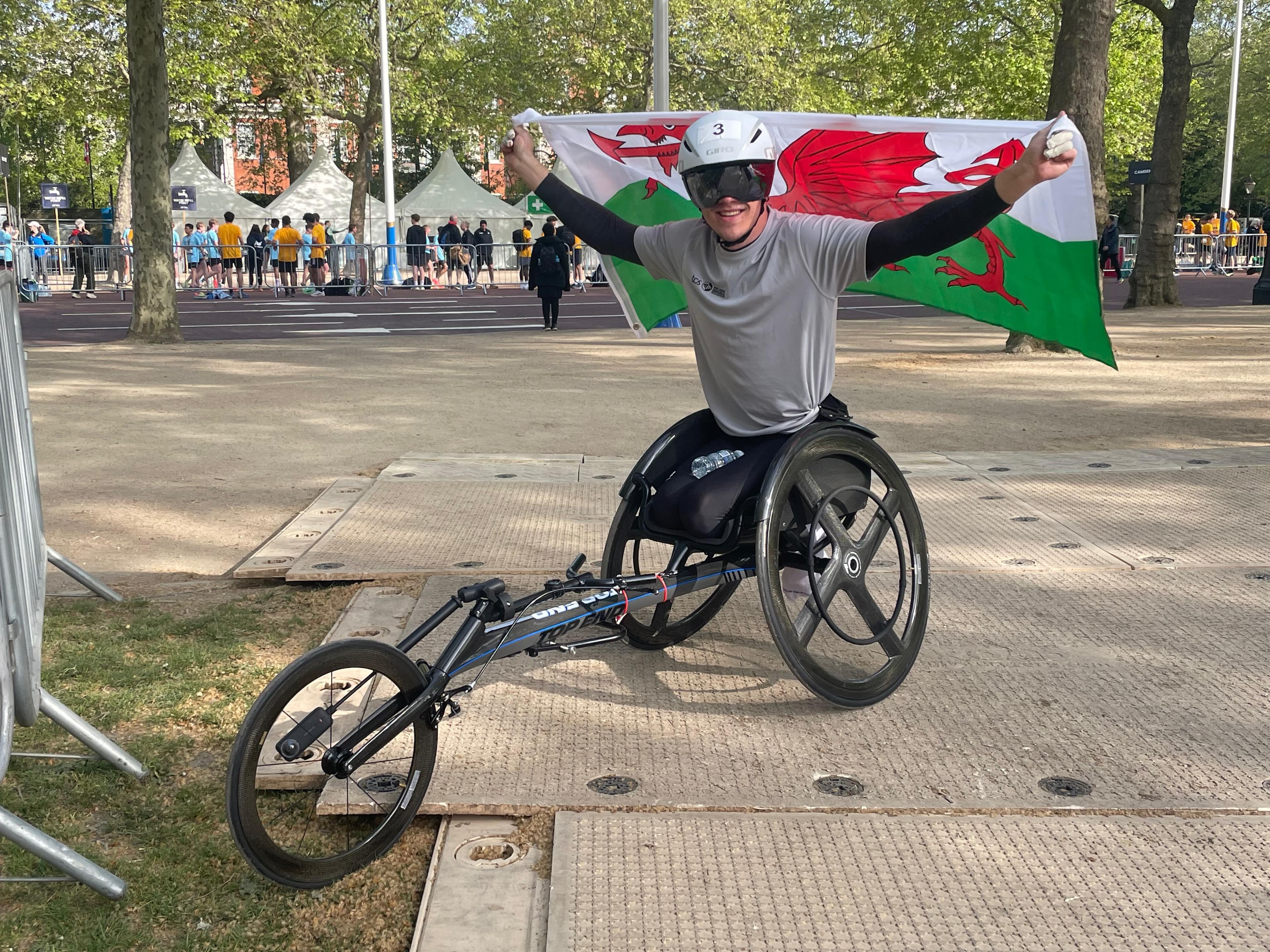 A wheelchair athlete celebrating with the Welsh flag
